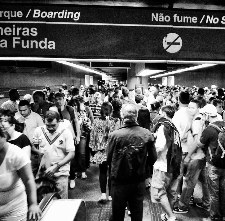 A crowded train station with streams of people passing in opposite directions.