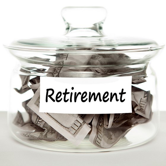 A glass jar labeled "retirement" is filled with cash. A glass jar labeled "retirement" is filled with cash.