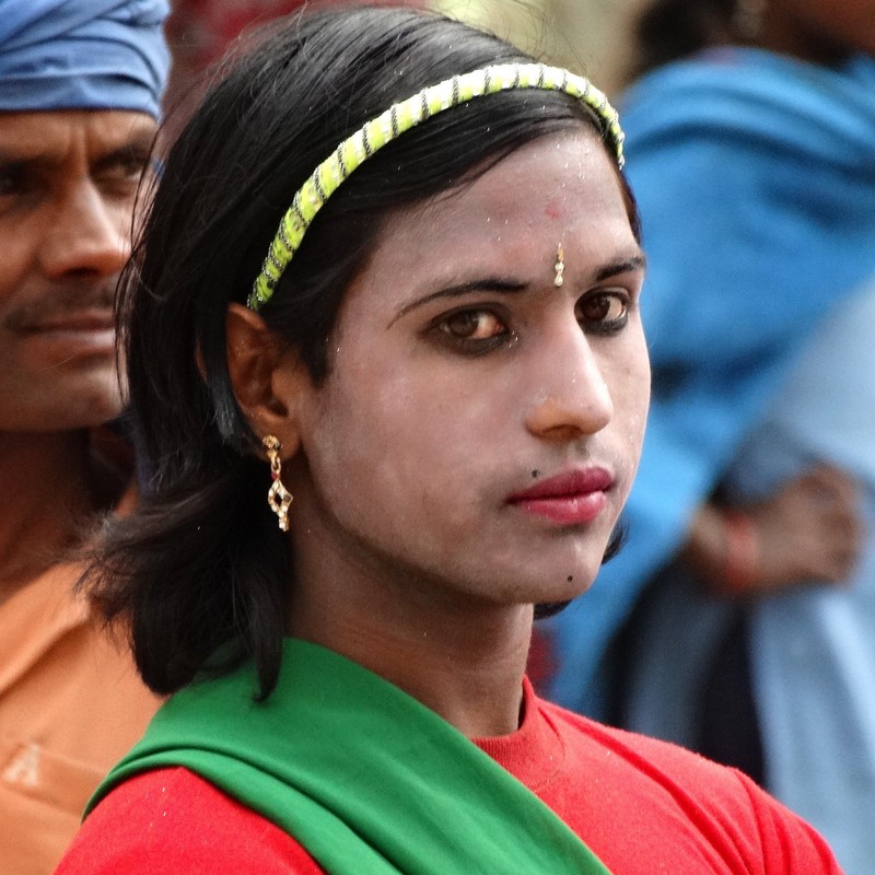 A hijra dancer with a feminine appearance wearing eyeliner, lipstick, and earrings. A hijra dancer with a feminine appearance wearing eyeliner, lipstick, and earrings.